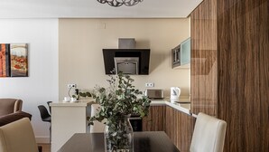 Una cucina moderna con forno a microonde integrato, macchina del caffè e tostapane sul piano di lavoro.