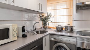 Una cocina moderna con horno empotrado, microondas, lavaplatos y fregadero.