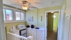 A compact kitchen with a ceiling fan, a microwave, a coffee maker, and a refrigerator. - Sky cozy apartment with rooftop views (Louisville)