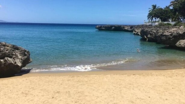 A sandy beach with clear blue water and rocky outcrops. - SUN AND SEA House (Sosúa)