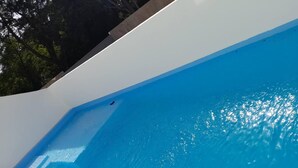 A swimming pool with clear blue water and a white edge. - SUN AND SEA House (Sosúa)