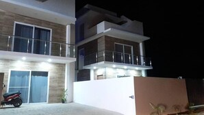 A modern two-story building with a balcony, large windows, and a motorcycle parked in front. - SUN AND SEA House (Sosúa)