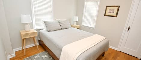 Una camera da letto con un letto, due comodini, un tavolino e un tappeto decorato.