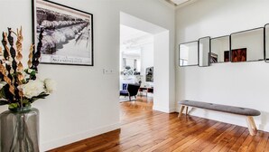 A hallway with wooden flooring, a bench, and a wall-mounted mirror display. - TOP OF THE RANGE - CHAMPS ELYSEE LUXE 110M2 (Paris)