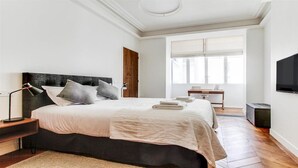 A modern bedroom with a large bed, bedside tables, a desk, and a TV. - TOP OF THE RANGE - CHAMPS ELYSEE LUXE 110M2 (Paris)