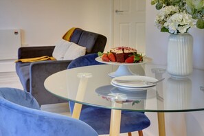 Relax in this stylish living room with a comfortable sofa and a glass-top coffee table.