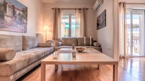 A living room with a sofa, a coffee table, and a painting on the wall. - Acropolis museum grand apartment (Athina)