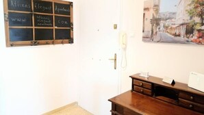 A room with a wooden desk, a white door, and a chalkboard with "Athens Elegant Apartments" written on it. - Stunning Acropolis view apartment (Athina)