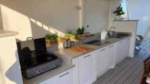 A compact kitchen with a built-in stove, a sink, and a countertop. - Salento Casa Relax (Vignacastrisi)