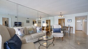A spacious living room with a large mirror, a glass coffee table, and a comfortable seating area. - The Crown Jewel of La Brisa 2 bdrm Monthly Spectacular ocean views. (Key West)