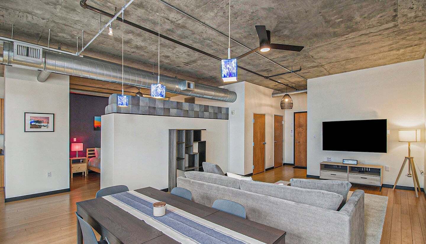 - Host dinners or game nights in this open concept layout with plenty of seating
- Industrial ceilings and modern lighting give the space a trendy downtown vibe
- Seamless flow from dining to living to bedroom areas adds convenience