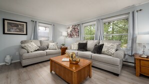 A living room with two sofas, a wooden coffee table, and a painting on the wall. - Close to Lewes with community pool, tennis & a fishing pier! 23290 Bridgeway (Lewes)