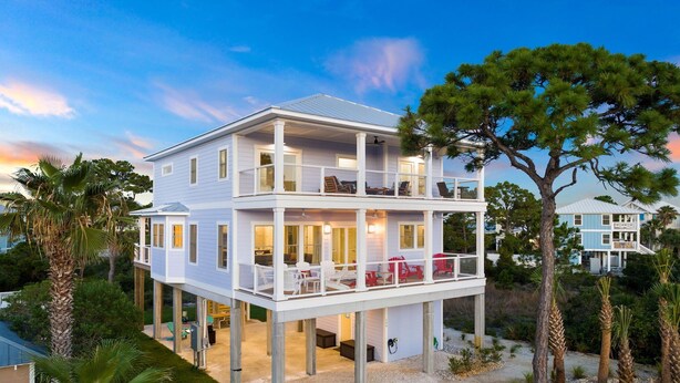 A two-story house with a balcony and a covered patio area. - Beach Escape w/ EV Charger and Pool (Port St. Joe)