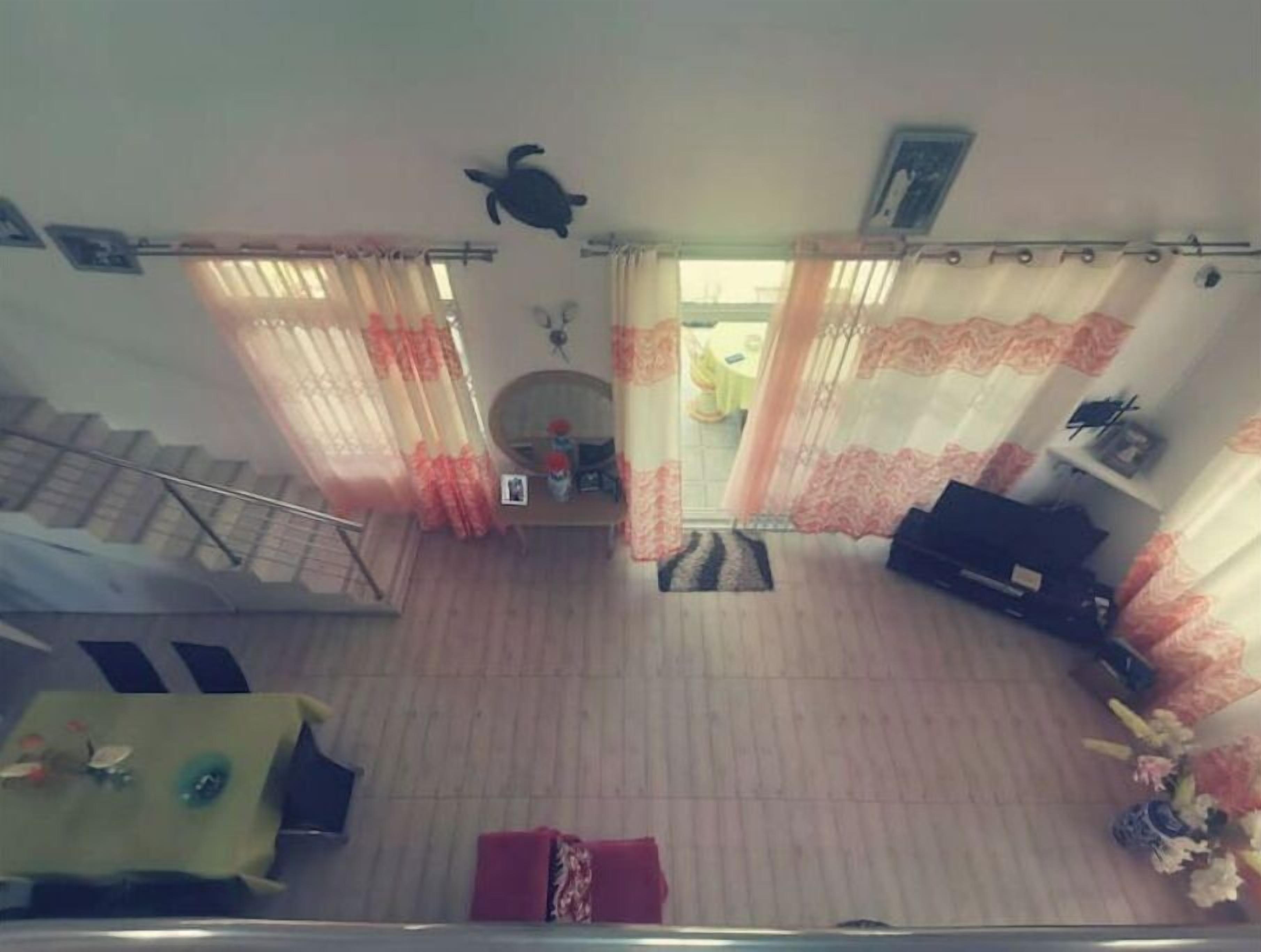 Ein großzügiger Wohnbereich mit Treppe, einer Couch, einem Fernseher und einem Esstisch.