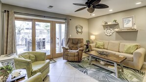 A living room with a sofa, armchair, coffee table, and a ceiling fan. - Sunset Rentals | Continental Club 6 (HIlton Head Island)