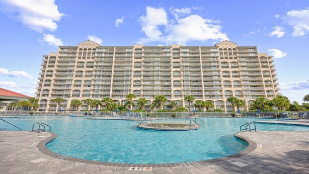 A large hotel with multiple balconies and a central swimming pool area. - Newly built, open-concept, and beautifully decorated 4 Bedroom in Barefoot Resort!<br>802 Dye Townhome (North Myrtle Beach)