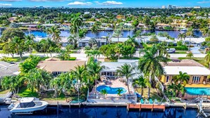 A residential area with a marina, a swimming pool, and several houses surrounded by palm trees. - Heated Pool! Kayak & Waterfront +1 Mile To Beach! (Pompano Beach)