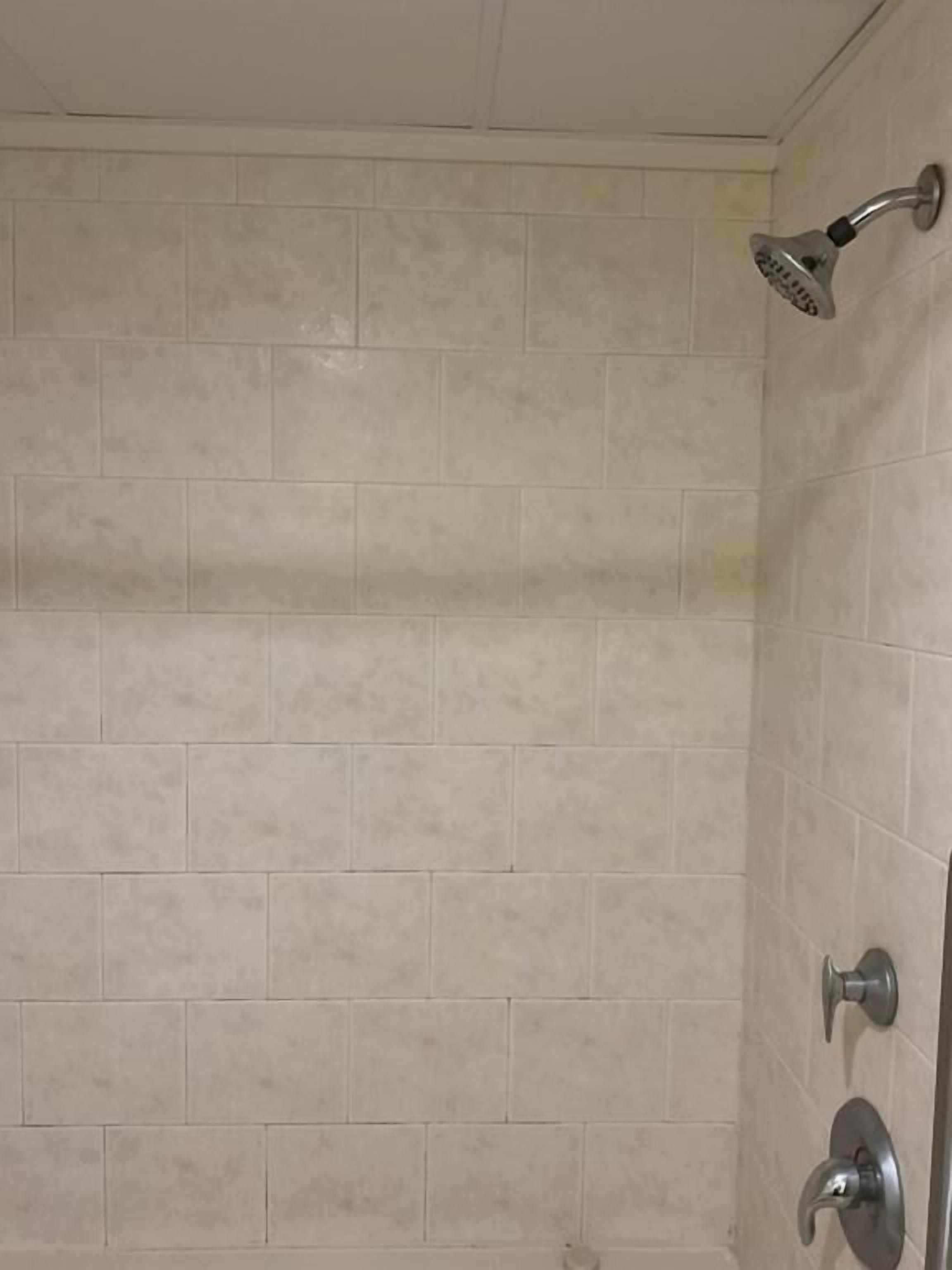 Ducha con cabezal de ducha de mano y grifo empotrado.
