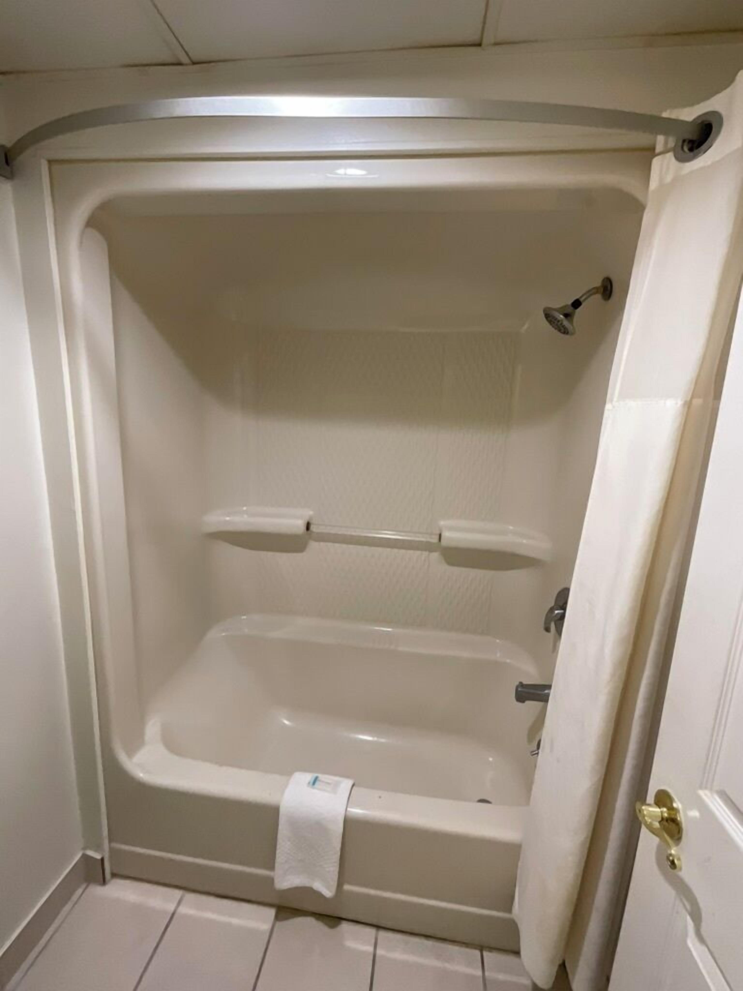 Une salle de bain équipée d’une baignoire, d’une douche et d’un porte-serviettes.