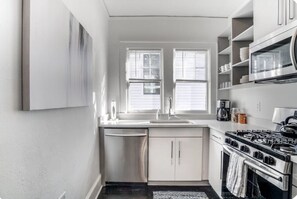 A compact kitchen with a dishwasher, stove, and microwave. - Historic Candler Park Gem! -Sleeps 4- Apt 3 - AC Atlanta (Atlanta)