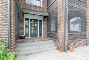 A brick building with a number '1625' above the entrance, a front door, and a small porch area. - Historic Candler Park Gem! -Sleeps 4- Apt 3 - AC Atlanta (Atlanta)