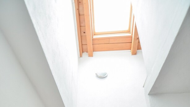 Una escalera con tragaluz que da a un techo de madera.