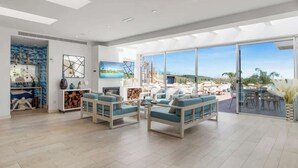 Un salón amplio con un gran ventanal corredera que da a un patio exterior.