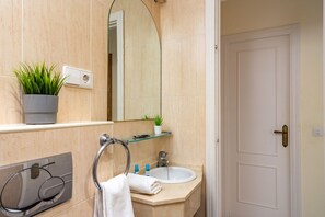 Bathroom features a glass shelf, towel rack, and large mirror.