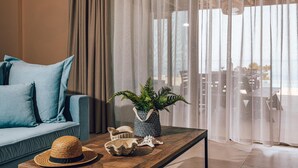 A modern living room with a sofa, a coffee table, and a decorative plant. - Terra Lucis Mountain Residences Mare Villa (Zakynthos)