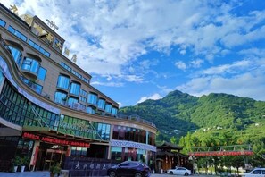 Un hôtel à étages, doté de grandes fenêtres et offrant une vue sur une montagne.