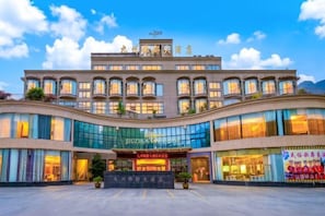 Un hotel con fachada moderna, amplias ventanas y una entrada destacada.