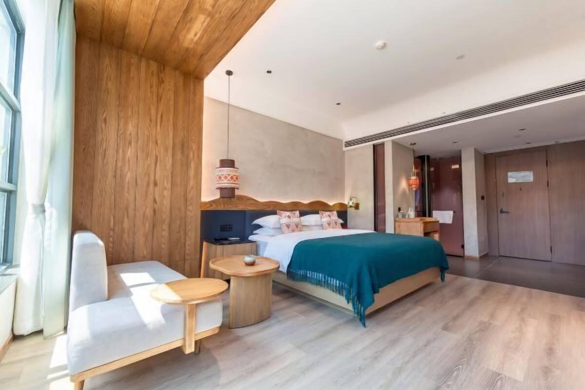 Une chambre d’hôtel moderne équipée d’un lit, d’un canapé, d’une petite table et d’un téléviseur.