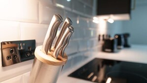 A modern kitchen with a stainless steel utensil holder on the counter. - Spacious 1BED Flat in Central Preston fast WiFi (Preston)
