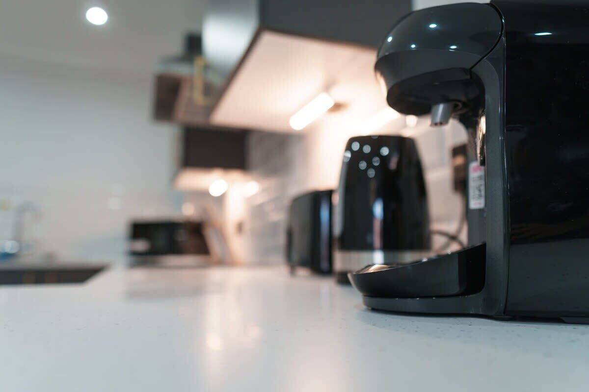 Une machine à café posée sur un plan de travail dans une cuisine moderne.