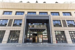 A hotel entrance with a modern facade, large windows, and a prominent sign. - Mini Home Boutique Hotel (Shiquan)