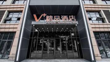 A modern building entrance with a glass facade and a sign indicating a boutique hotel.
