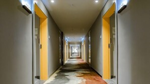 A hotel hallway with a long, narrow corridor, doors on both sides, and a patterned carpet. - Mini Home Boutique Hotel (Shiquan)
