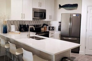 Een koelkast, een oven, een kookplaat, een koffiezetapparaat/waterkoker