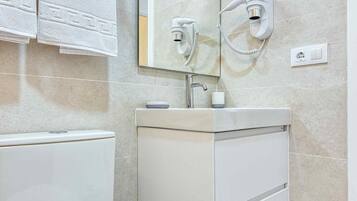 A modern bathroom with a toilet, sink, and towel rack.