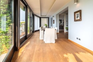 Ein modernes Interieur mit Essbereich, großen Fenstern und Blick auf Grünflächen.