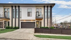 A modern two-story house with a garage, a balcony, and a well-maintained lawn. - Stylish & Perfectly Located Deluxe 2-Bed Townhome (Dallas)