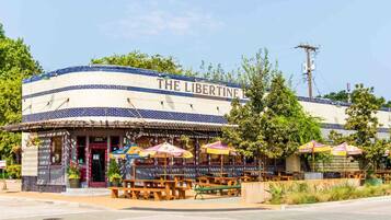 Un restaurante llamado "The Libertine" con terraza y fachada azul y blanca.