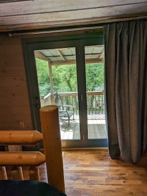 Enjoy a serene view from the deck, complete with a table and chairs, surrounded by lush greenery.