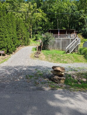 Escape to a serene cabin surrounded by lush greenery, with a deck and porch.