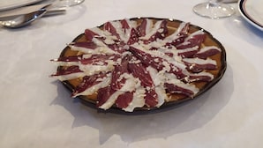 A dining table with a plate of food, wine glasses, and cutlery. - Eco dos Teixos (Carballeda de Valdeorras)