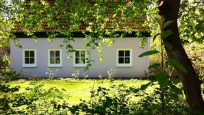 A house with a white exterior, a red-tiled roof, and three windows. - Charming artist's studio (Worpswede)