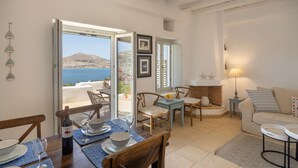 Un salon chaleureux avec un coin repas, un canapé et une vue sur la mer.