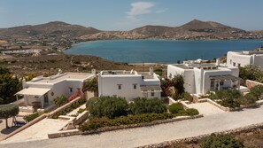 A coastal village with white buildings, a clear blue sea, and mountains in the background. - Naousa Bay Views with pool - Villa Caroline (Naousa)