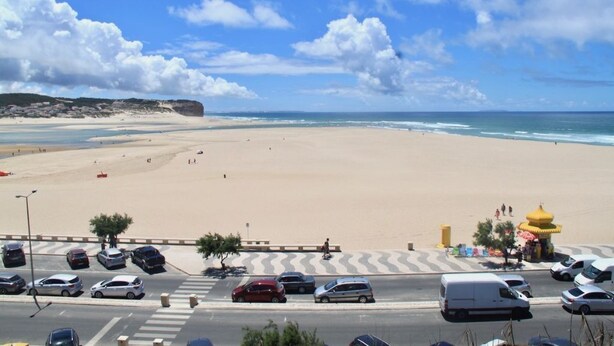 Una spiaggia con un’area parcheggio e una struttura gialla.