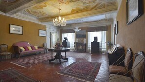 A spacious room with a large chandelier, a piano, and a sofa. - Villa Raffaelli, original Tuscany villa from 1582 (Fosciandora)